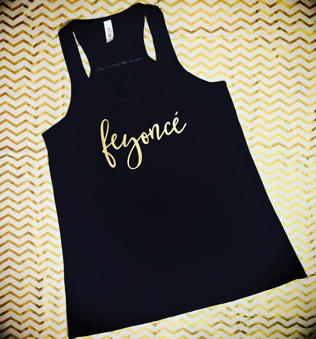 Black tank top with gold cursive feyoncé text on gold chevron background