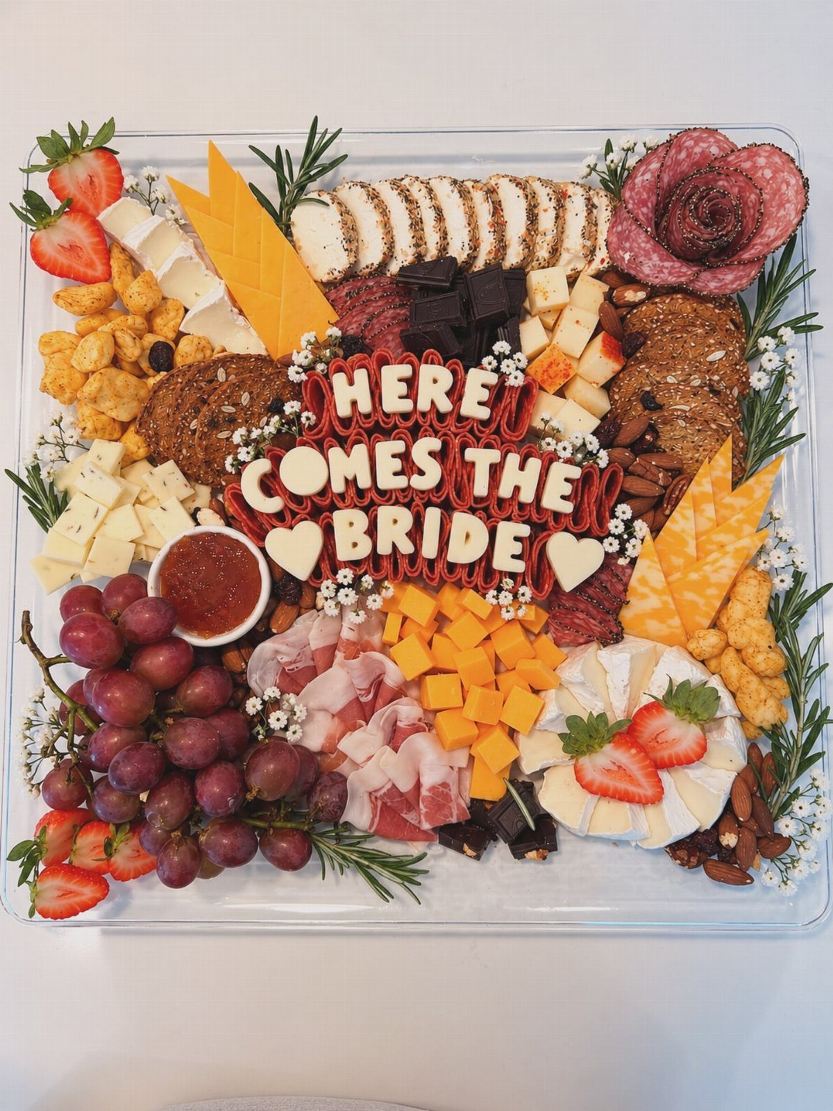 Fruit and cheese platter with cured meats and 'Here Comes The Bride' lettering.