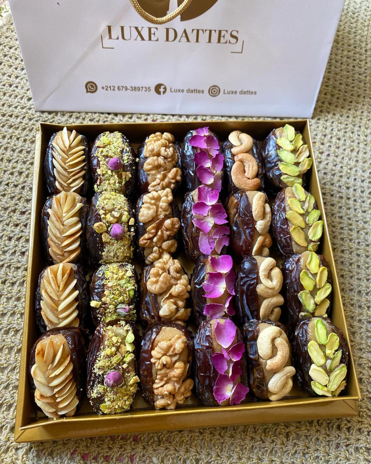 Gourmet stuffed dates with nuts and rose petals in a gold gift box.