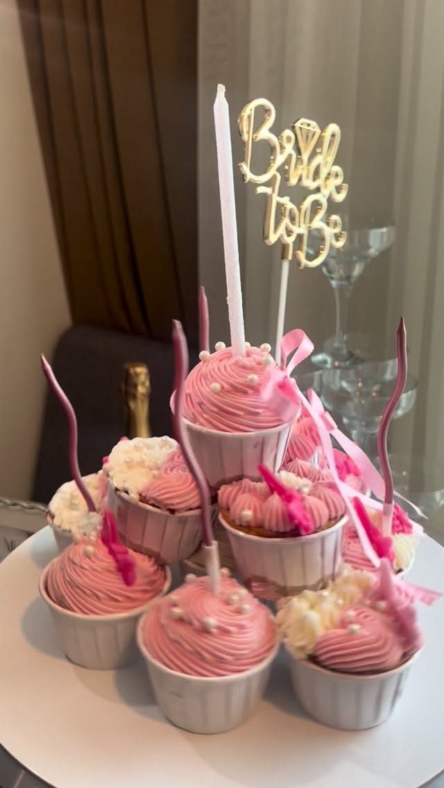 Mini cupcakes with pink frosting and a gold Bride to Be cake topper.