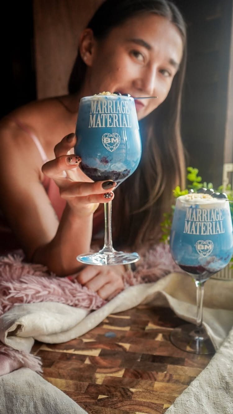 Blue cocktails in glasses printed with Marriage Material held by a woman