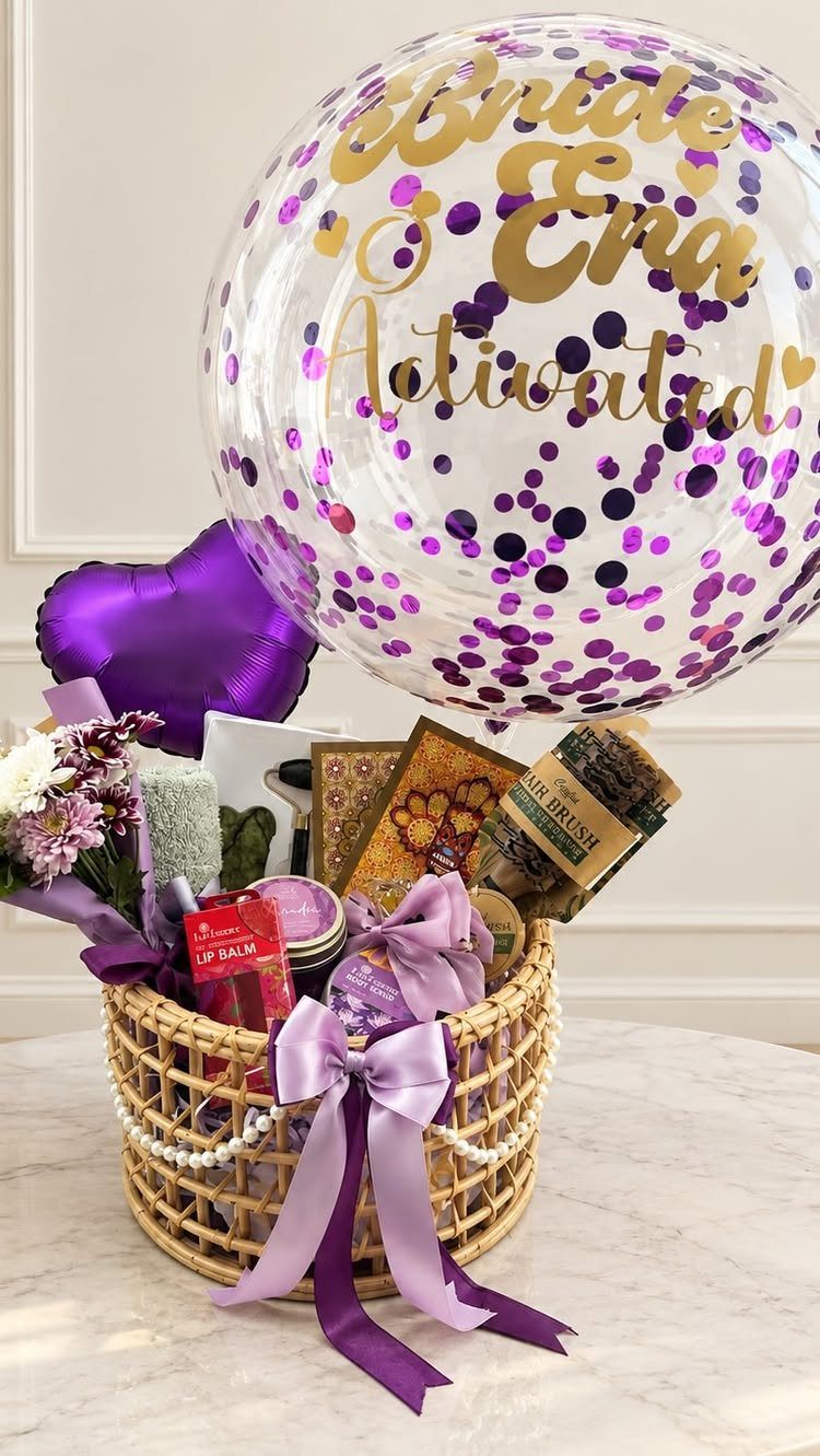 Wicker gift basket with spa products and a large 'Bride Activated' confetti balloon.