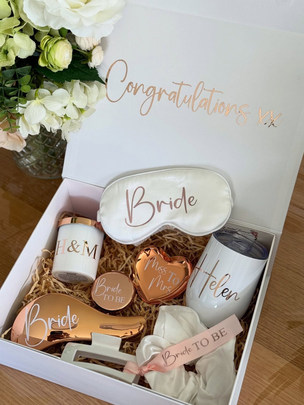 Bridal gift box containing a sleep mask, tumbler, candle, and rose gold accessories.