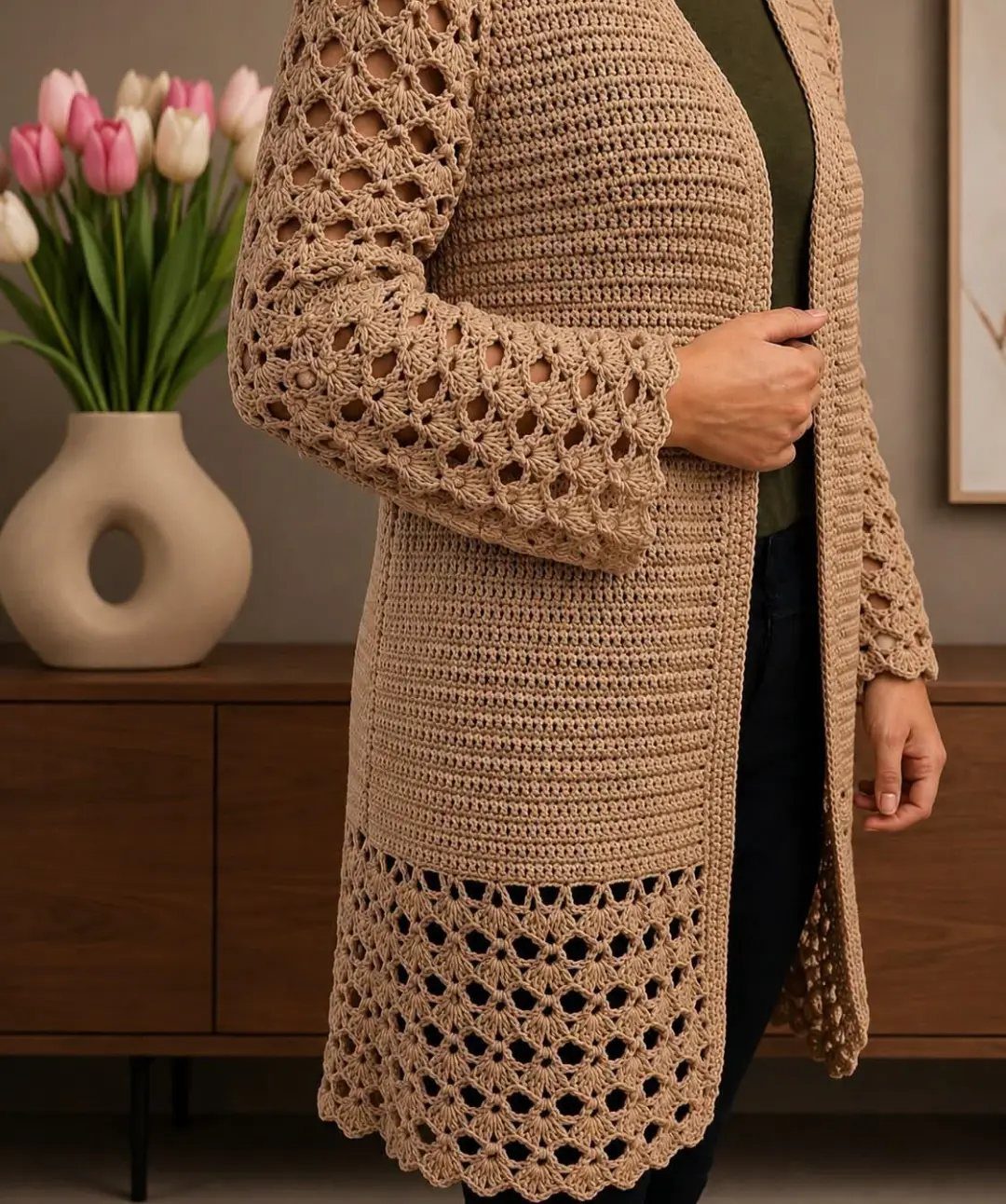 Tan crochet cardigan worn over a green top with tulips in background