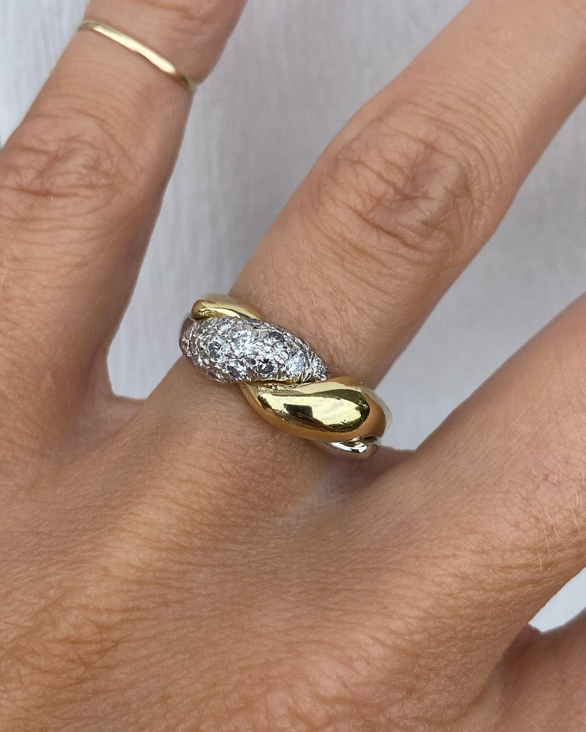 Mixed metal ring with gold and silver tones and diamonds on a finger