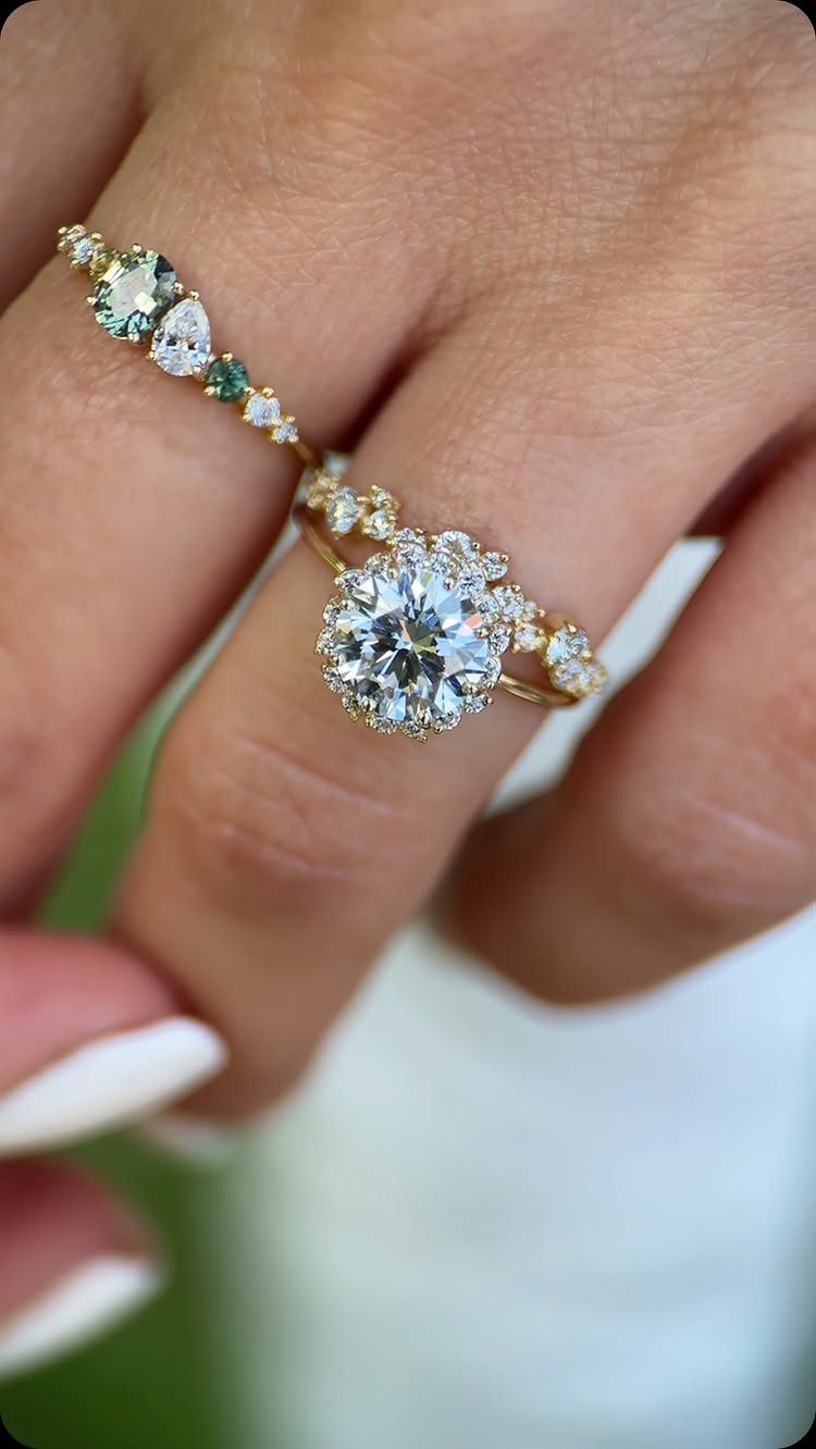 Halo engagement ring with a large center diamond and a gemstone wedding band.