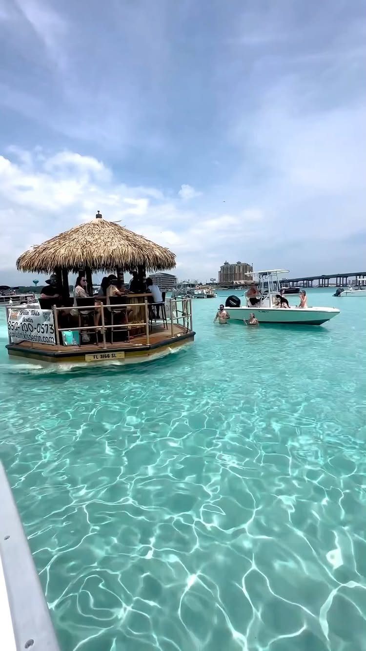 Floating tiki bar with thatched roof in clear turquoise tropical ocean water