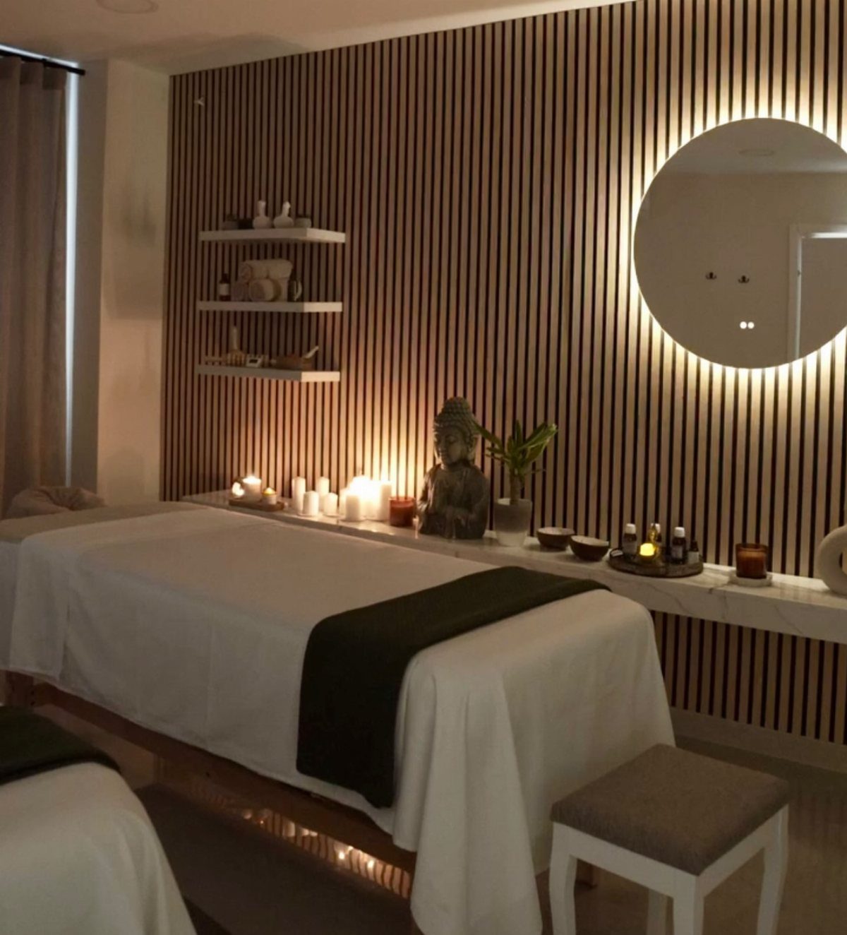 Massage table in a luxury spa room with wooden walls and glowing candles.