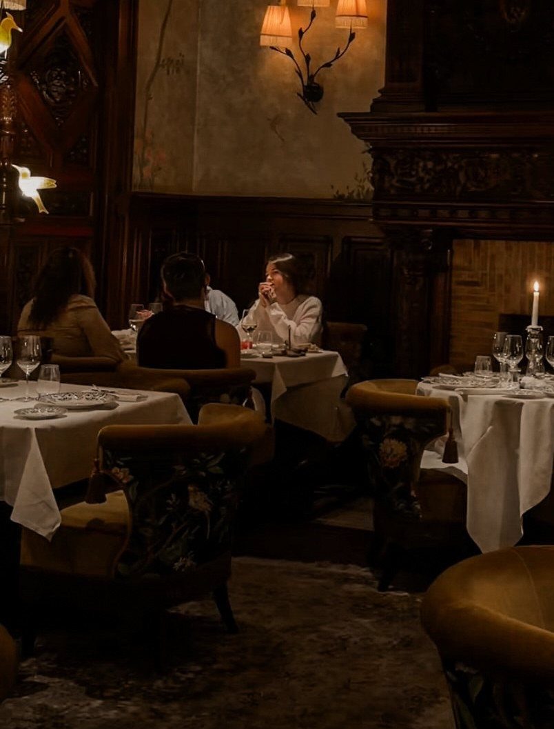 Candlelit dinner at a luxury restaurant with white tablecloths and ornate decor.