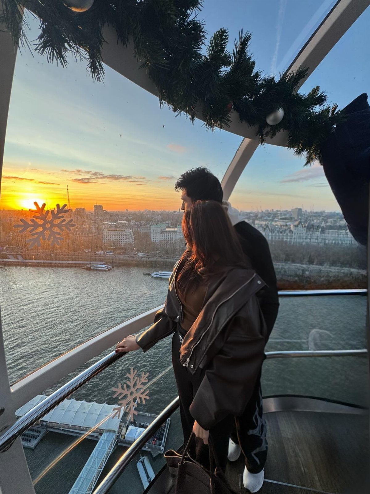 Couple looking at the London skyline from inside a London Eye capsule
