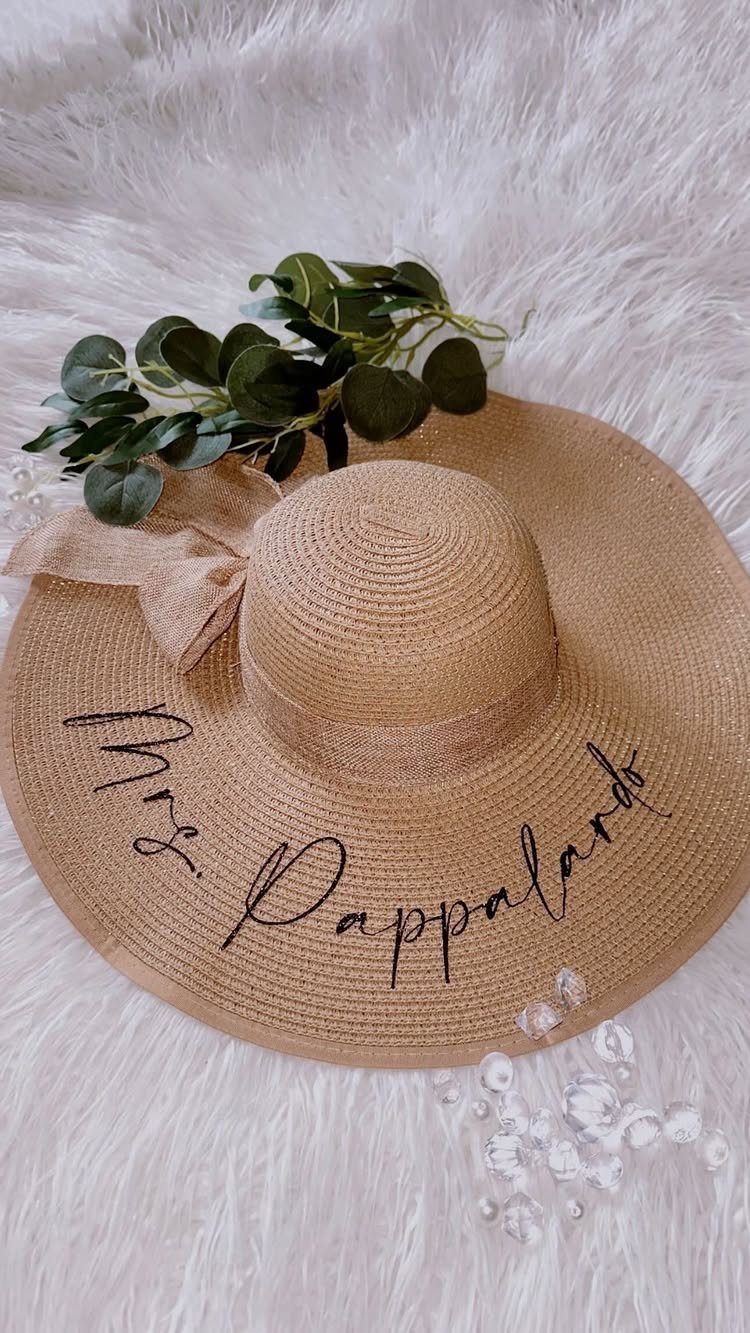 Straw floppy hat with Mrs. Pappalardo written on the brim on white fur.