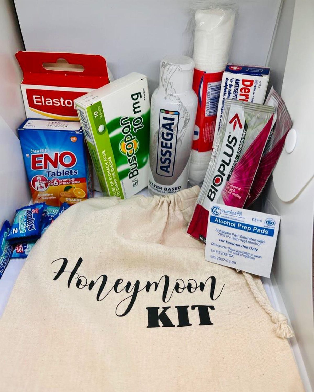 Honeymoon kit bag and various medical supplies arranged inside a white box.