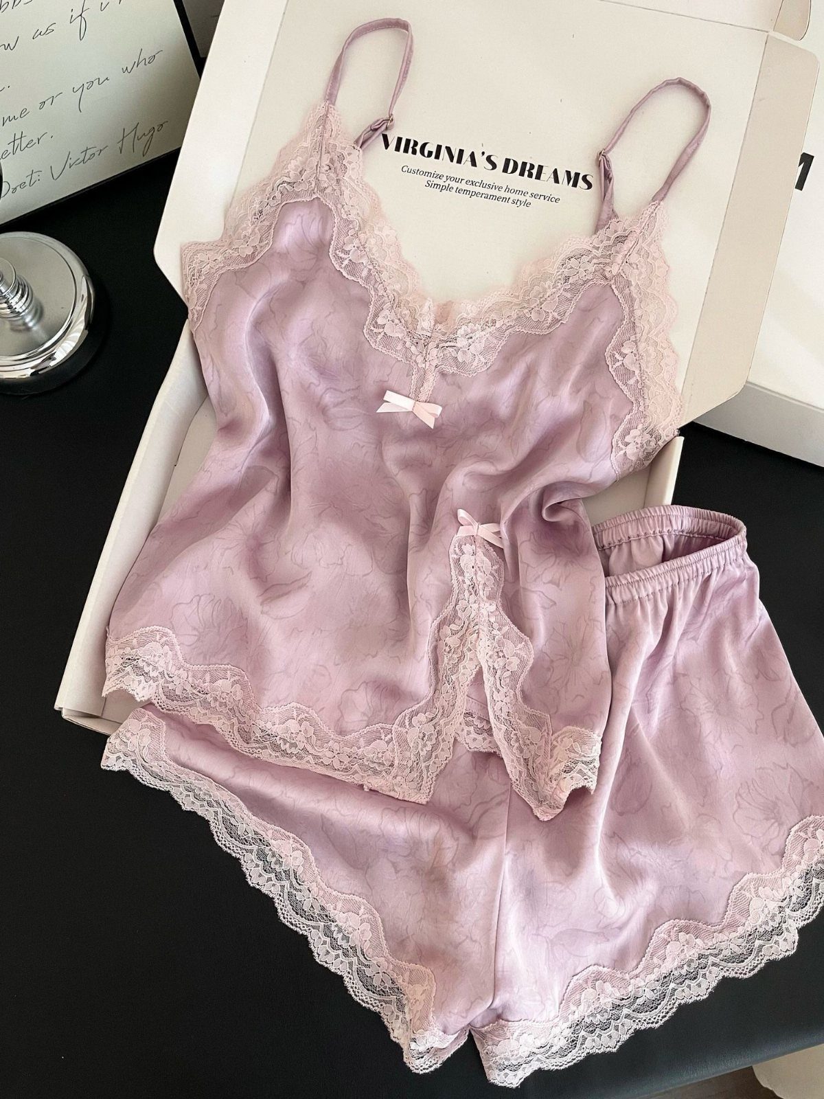 Light purple satin pajama set with lace trim inside a white box.