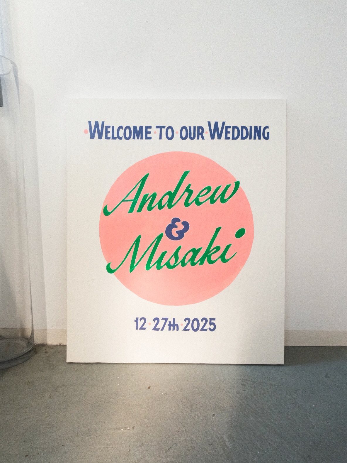 Wedding welcome sign with names Andrew and Misaki in green cursive script.