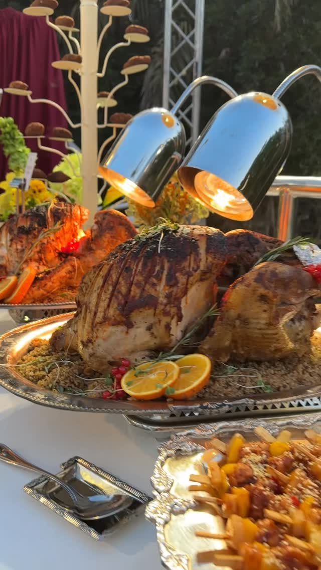 Roasted turkeys on silver platters under heat lamps at a buffet service.