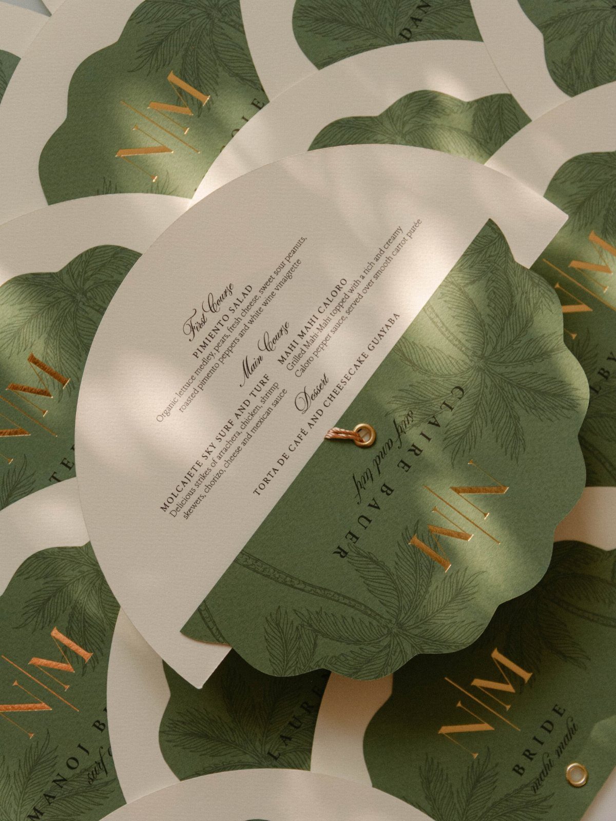 Circular wedding menus with green botanical designs and printed course descriptions.