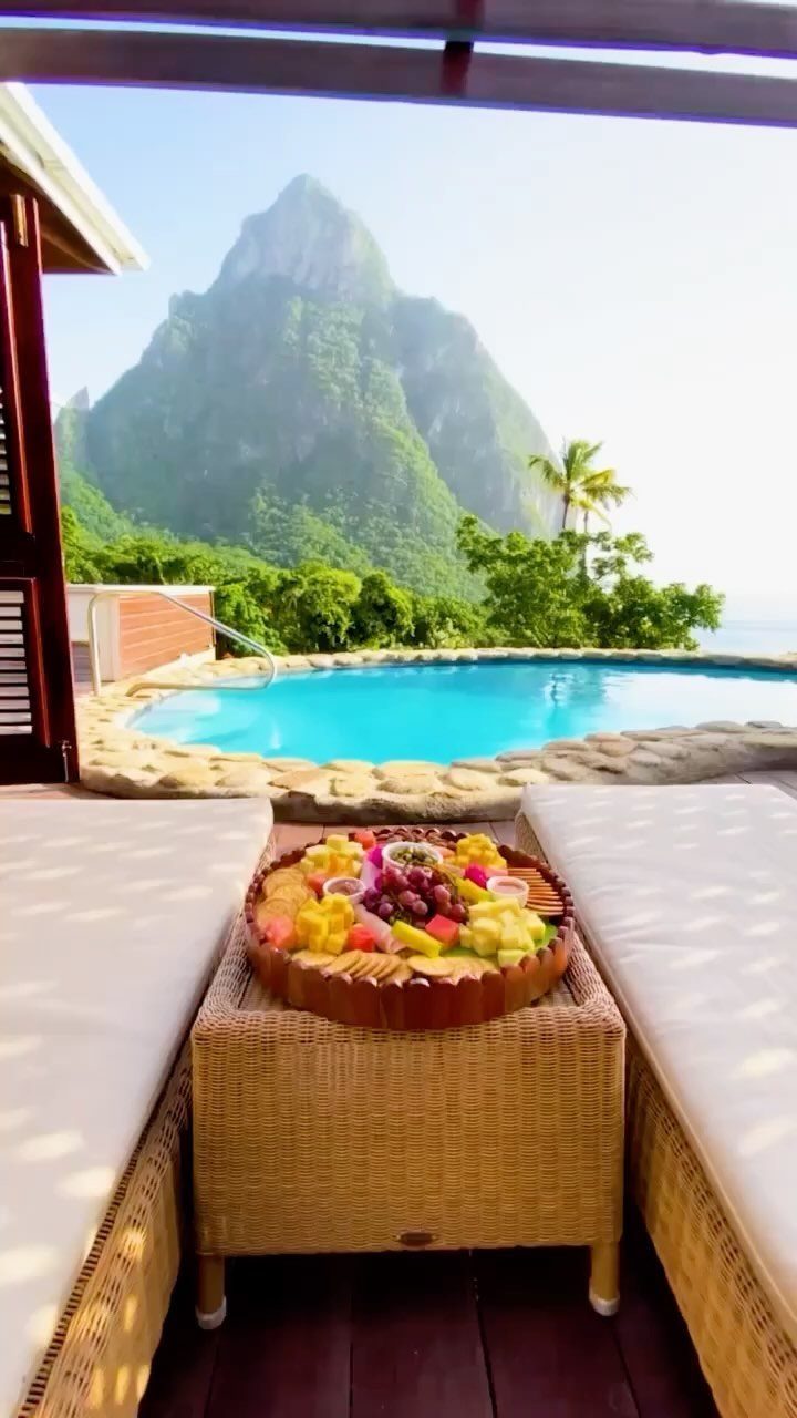 Lush green mountain peak viewed from a luxury resort balcony with a pool.