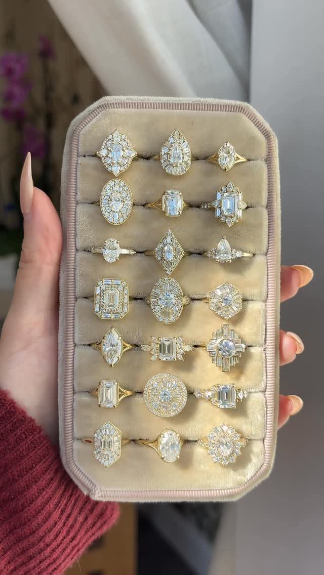 Gold engagement rings with various diamond cuts displayed in a beige velvet case.