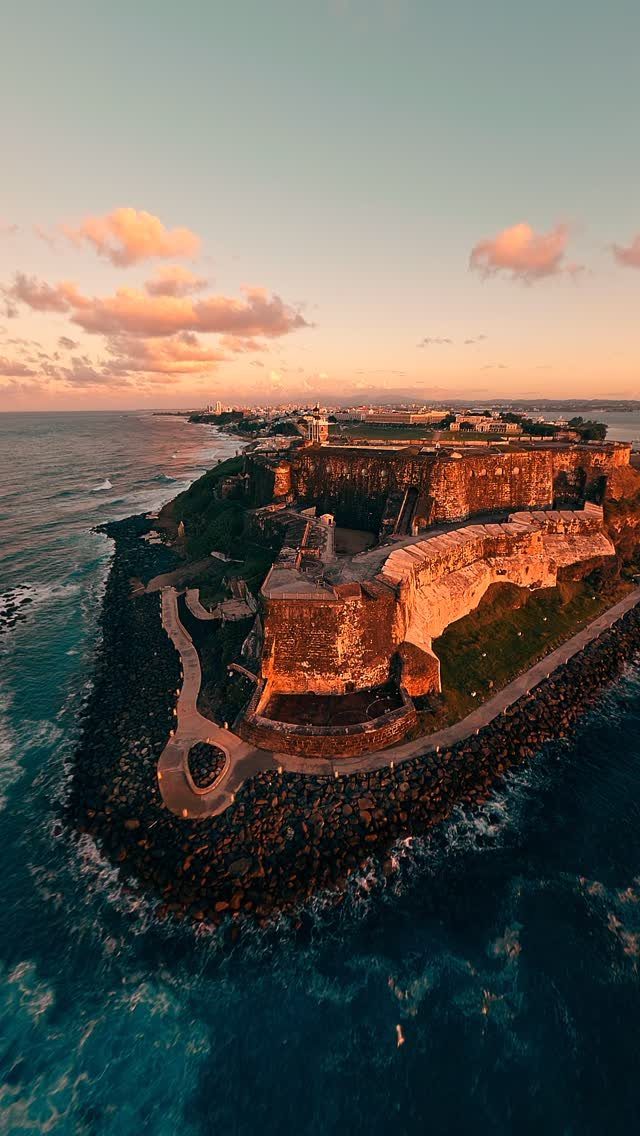 Castillo San Felipe del Morro stone fortifications overlooking the ocean at sunset.