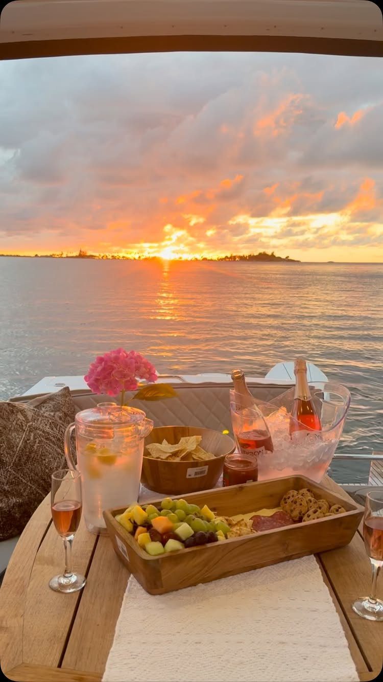 Romantic sunset dinner setup on a boat with wine and fruit over the ocean