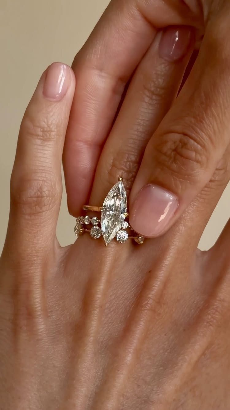 Gold ring stack featuring a marquise diamond engagement ring and two diamond bands.