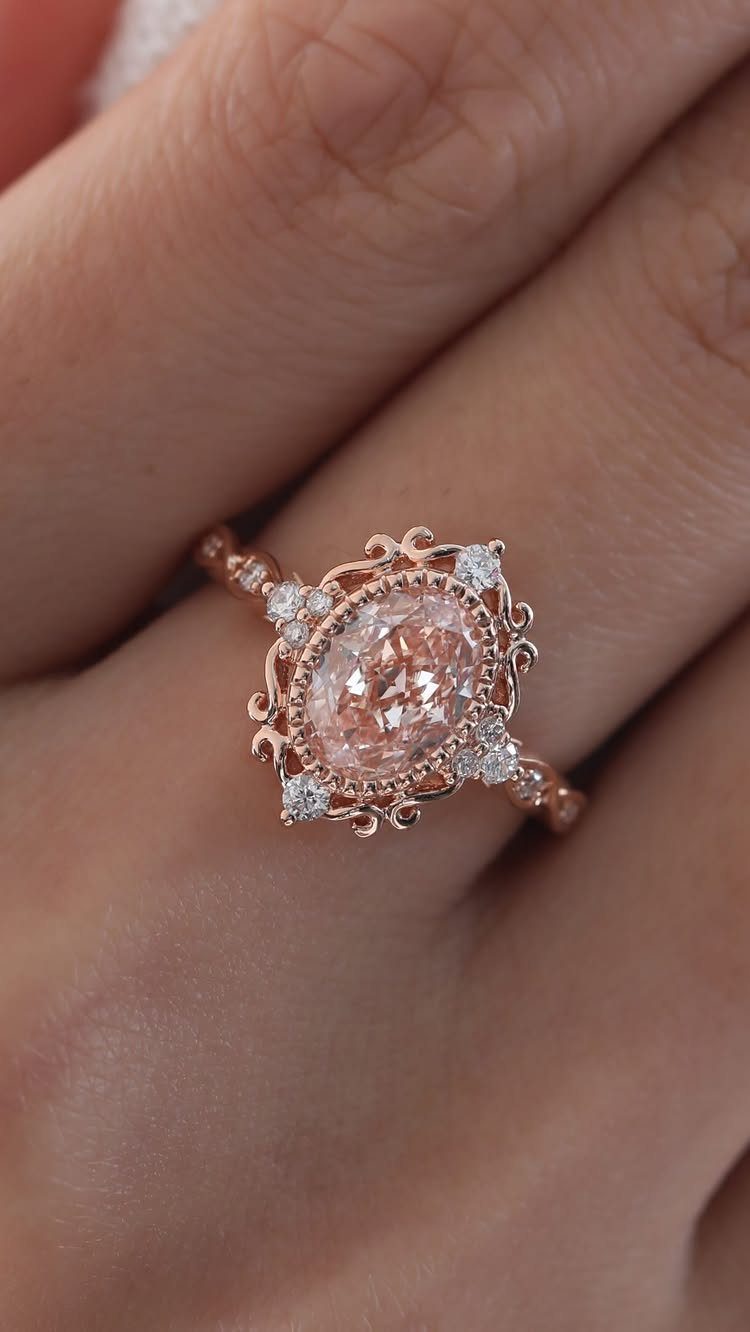 Rose gold vintage ring with oval diamond and ornate filigree setting on finger