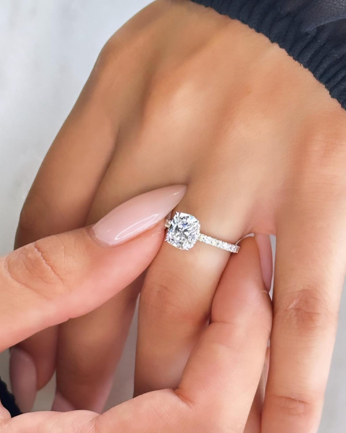 Silver diamond ring with a large center stone on a woman's finger