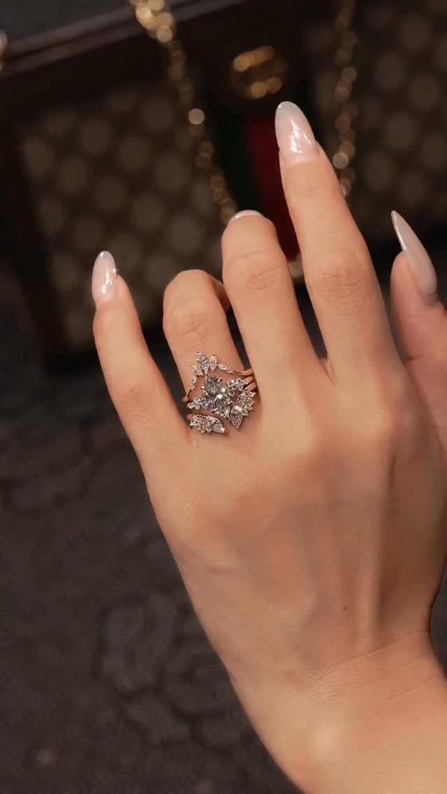 Intricate rose-gold diamond ring set with leaf-like designs on a woman's finger