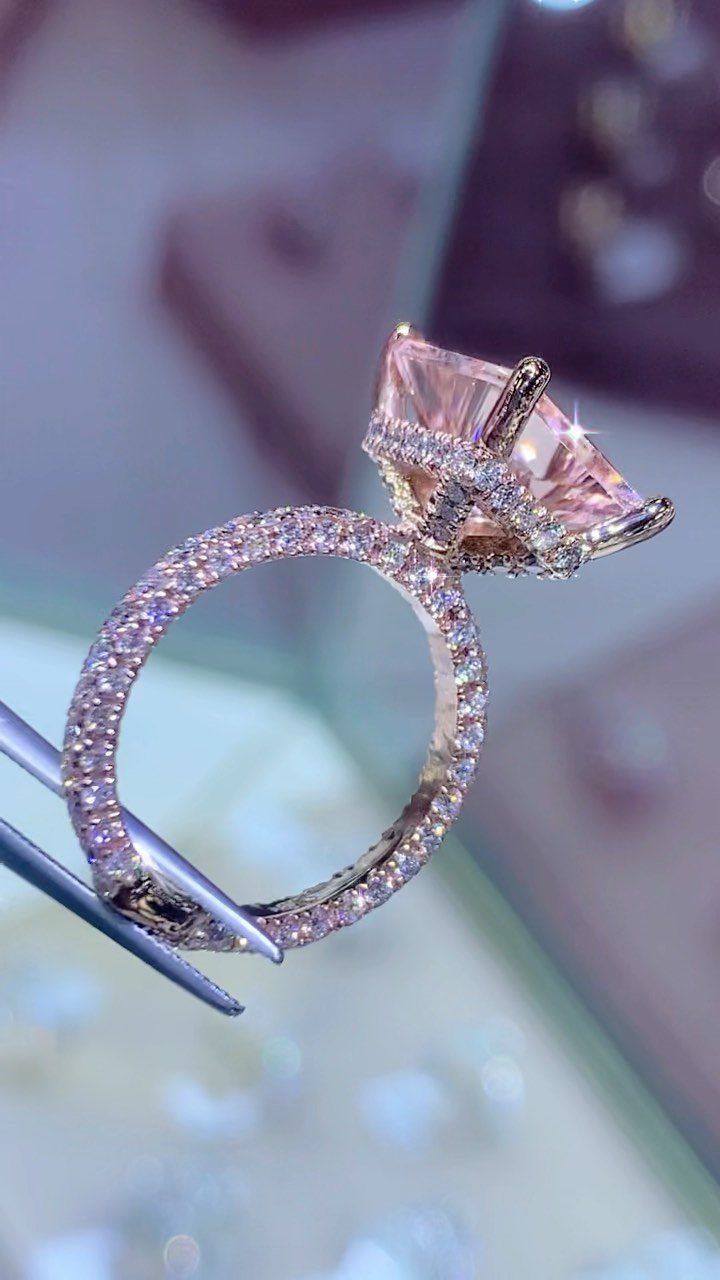 Rose gold wedding ring with a large pear-shaped peachy-pink morganite center stone.