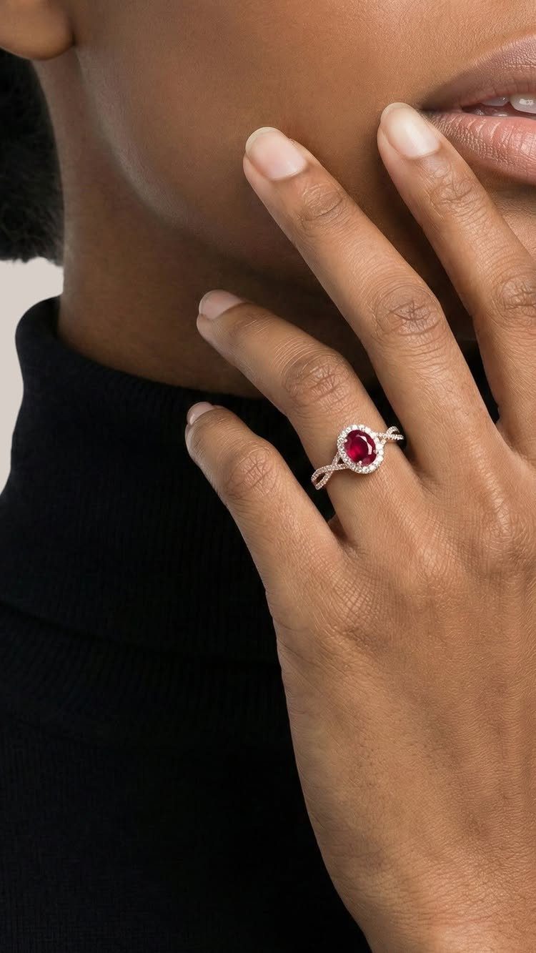 Silver ring with a red ruby gemstone worn on a person's finger