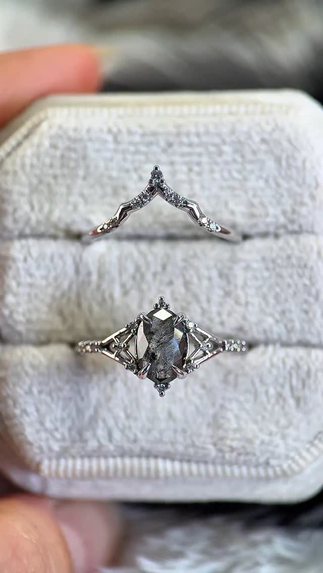 Two silver rings with speckled grey diamonds in a white velvet box