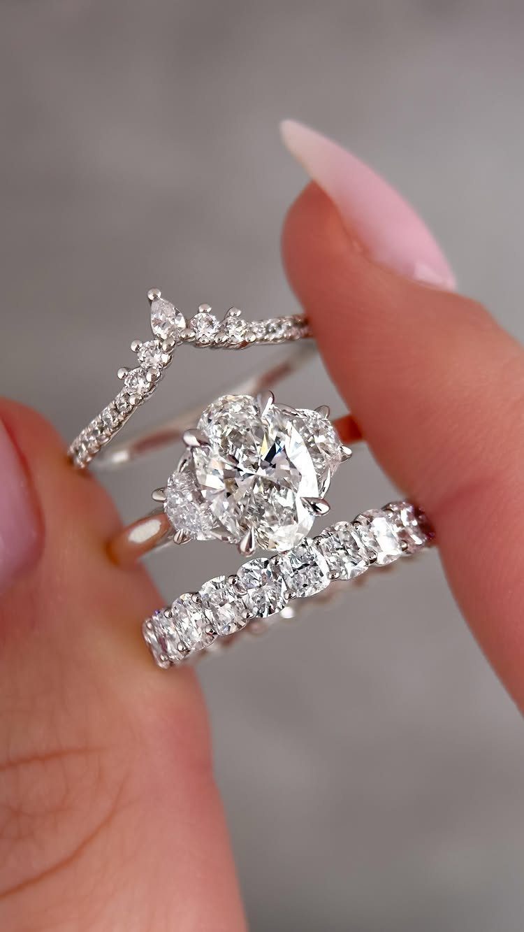 Curved diamond wedding band paired with a solitaire engagement ring on fingers.
