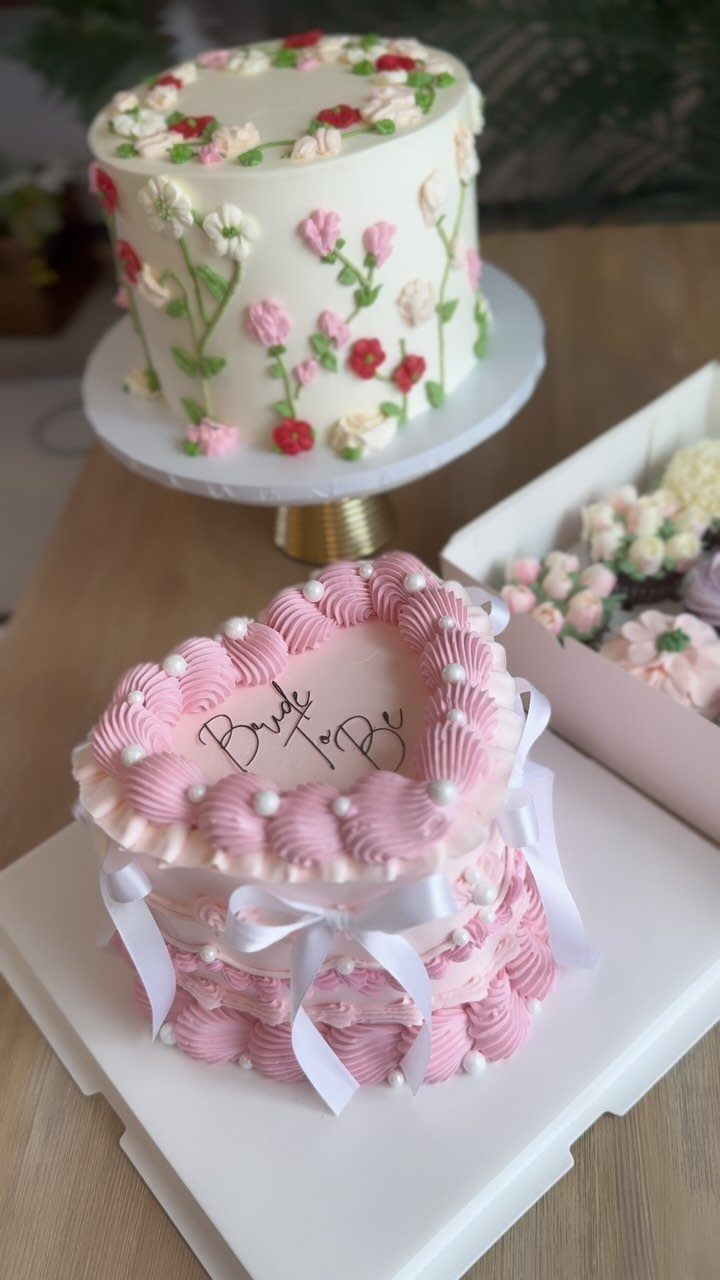 Heart-shaped pink cake with white ribbons and Bride To Be lettering