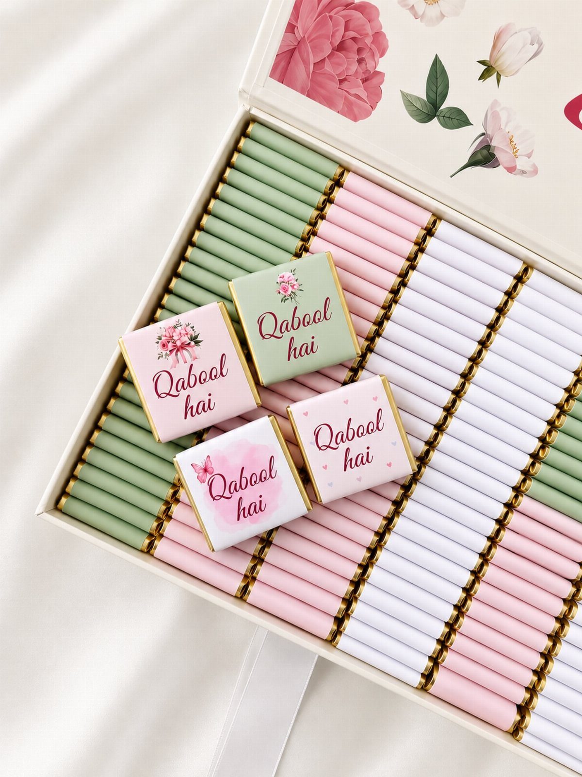 Box of pastel wrapped chocolates with floral designs and Qabool hai text.