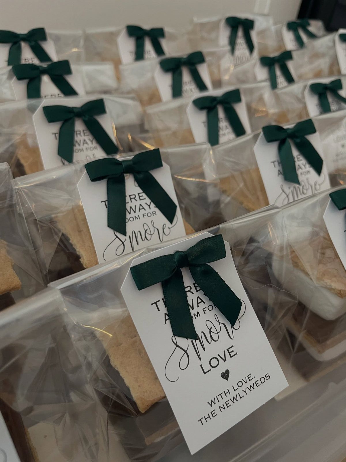 S'mores kit favor bags with green ribbons and S'more Love tags for weddings.