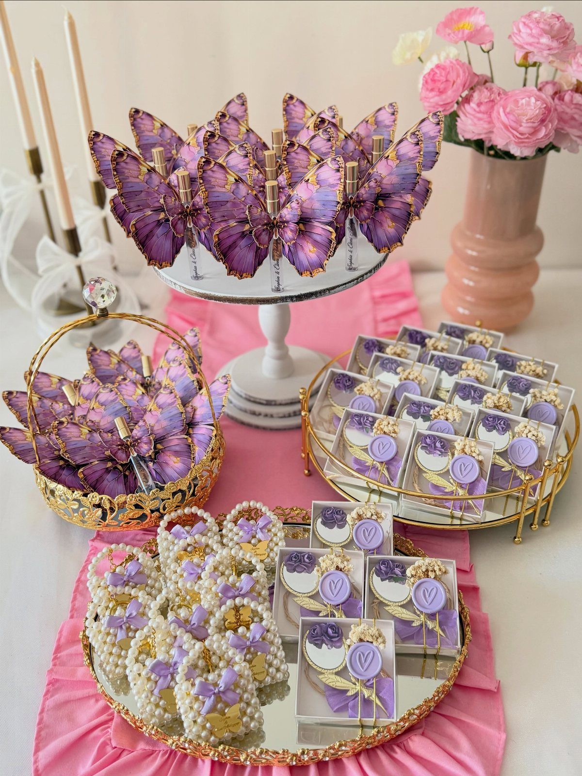Purple and gold butterfly themed party favors arranged on gold trays and stands.
